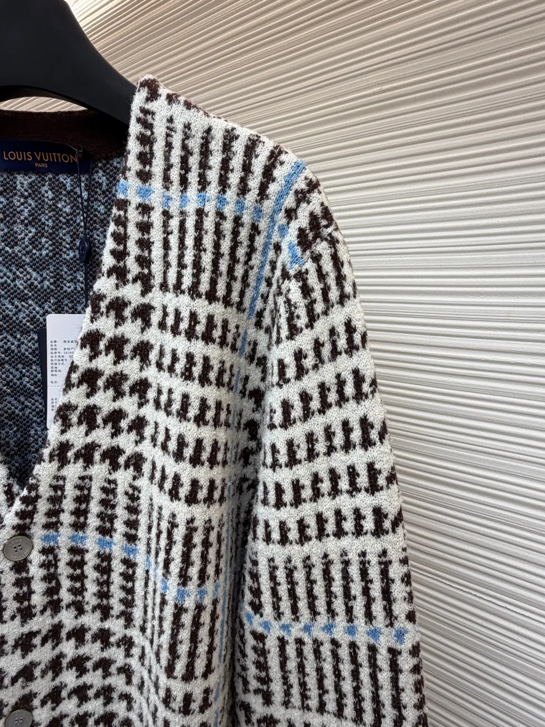 LOUIS VUITTON letter intarsia houndstooth knitted jacquard cardigan ●Original version: purchased and developed by 14743 ●Item number: 1681873-C00 ●Fabric: wool blended fabric ●Technology: jacquard knitting ●Color: black, white and blue ●Version: fitted version ●Weight: about 695 grams ●Size: S-M-L-XL ●Description: The main pattern of this cardigan is woven with full-width jacquard technology, using 69% sheep wool blended with 31% nylon yarn to interweave the houndstooth pattern with light blue line texture. At the same time, the brand logo elements are integrated into the body through intarsia technology, and the edges of the pattern are connected delicately and seamlessly. The collar, cuffs and hem are made of 100% sheep wool ribbed fabric, and are edged with double-needle seaming technology, which has both elasticity and shaping effect. The front placket is equipped with natural-textured buttons, and the side seam pockets use invisible stitching technology to blend naturally with the jacquard texture of the body. The overall shape is shaped through three-dimensional tailoring, and the shoulders are stitched with seamless stitching to ensure fit and comfort. The entire piece is finished with handcrafted details in an Italian workshop, showing the craftsmanship precision of high-quality knitted items. The overall wiring is straight and delicate, the fabric is comfortable and soft, and the color is consistent without color difference. It can be matched with the same style to create a fashionable look and control various occasions. Customized accessories, complete with three standards, same style for men and women!